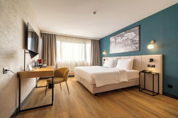 Metropolis Hotel features a modern facade with a prominent entrance and lush surroundings.