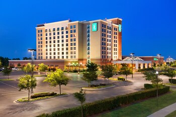 A multi-level hotel lobby with a central fountain, seating areas, and a bar/lounge.