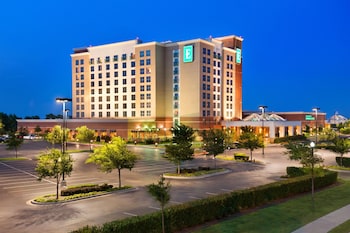 A multi-level hotel lobby with a central fountain, seating areas, and a bar/lounge.