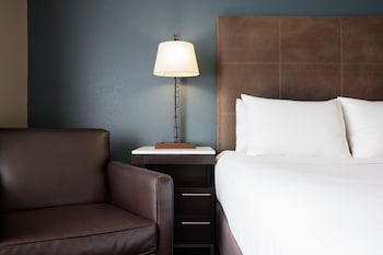 Un hotel de varios pisos con una entrada destacada, área de estacionamiento y un cartel que indica que es un Hyatt House.