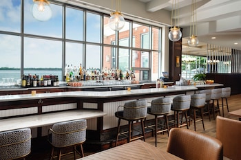 A Sheraton hotel with a modern design, featuring a large glass facade and a waterfront view.