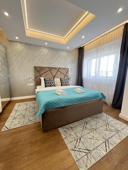 A modern interior with a hanging chair, wooden flooring, a kitchen area, and a dining space.