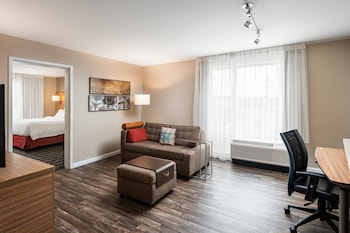 Un espace extérieur aménagé avec un foyer en pierre, des meubles en osier et une terrasse couverte.