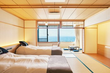 A pool with a view of the sea and a wooden structure.