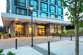 An outdoor seating area with wicker furniture and a glass building in the background.