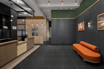Una zona de bar moderna con una barra alargada, taburetes y una iluminación ambiental.