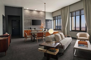 A modern living room with a large bookshelf, two armchairs, and a coffee table.