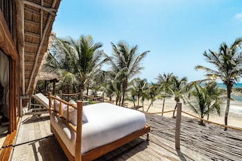 Een privéstrand, wit zand, ligstoelen aan het strand, parasols