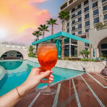 Alberca al aire libre, sombrillas en la alberca y camastros