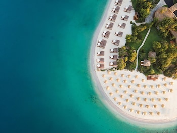 Plage privée, sable blanc, cabines (en supplément), chaises longues