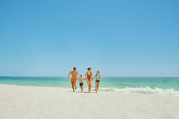 On the beach, white sand, sun loungers, beach umbrellas