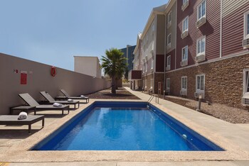 Hotel features a modern design with a mix of brick and stucco exteriors, multiple levels, and a welcoming entrance.