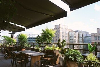 Un bâtiment moderne avec une grande enseigne lumineuse sur laquelle on peut lire « Calvin » et une enseigne au néon indiquant « EN DIRECT ».