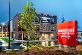 An outdoor patio area with seating, a fire pit, and street lamps.