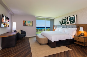 A large, circular hotel with multiple floors, surrounded by lush greenery and a pool area.