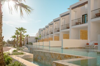 Relax by the pool with a clear view of the horizon, surrounded by sun loungers and umbrellas.