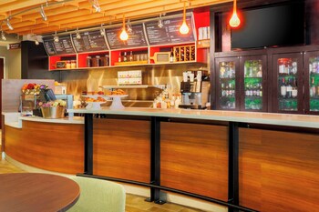 A bar area with a wooden counter, menu boards, and a beverage display.
