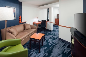 A hotel lobby with a fireplace, seating area, reception desk, and a clock on the wall.