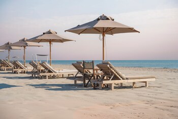 Plage privée, cabines (en supplément), serviettes de plage, bar de plage