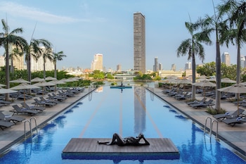 Alberca al aire libre, sombrillas en la alberca y camastros