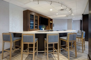 Una cocina moderna con armarios de madera, una encimera con diversos electrodomésticos y una pared de pizarra con mensajes inspiradores.