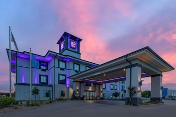 Stunning hotel entrance with a flat roof and symmetrical design, featuring a covered entrance and evenly spaced windows.