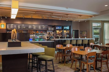 Uma área de bar moderna com um quadro de cardápio, assentos e o logotipo da Starbucks.