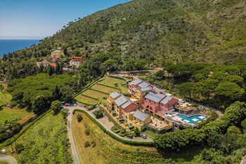 Zona junto a la piscina con sillones de descanso y vistas a un paisaje montañoso.