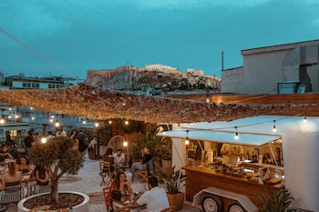 An indoor courtyard with tables and chairs, a central tree, and a food display.