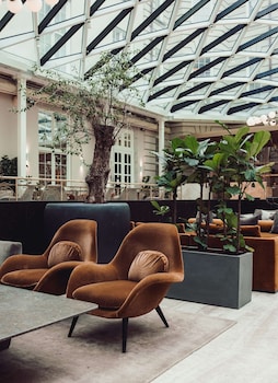 A spacious lobby with a high ceiling, multiple seating areas, and a central fountain.