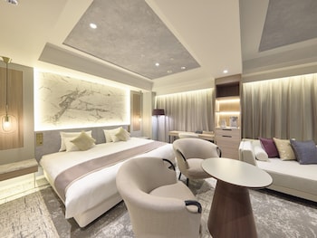 A modern lobby with a geometric patterned floor, contemporary seating, and large windows offering views of the cityscape.