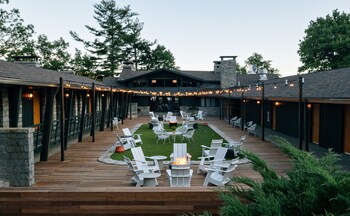 A spacious bar area with high ceilings and large windows, offering views of trees and a clear sky.