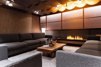 Ein modernes Wohnzimmer mit Sofa, Couchtisch und Kamin.