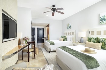 Enjoy breathtaking ocean views from your balcony amidst lush greenery and palm trees.
