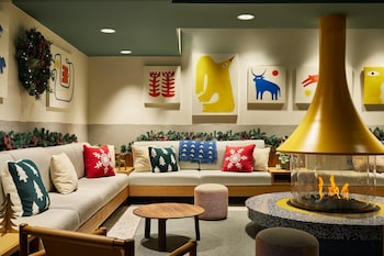 A modern living room with a sectional sofa, a wooden coffee table, a side table with a lamp, and a large window with a view.