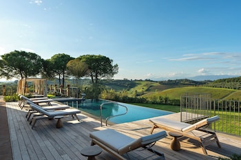 A doorway leading to a pool area with outdoor furniture and a scenic view of hills and water.