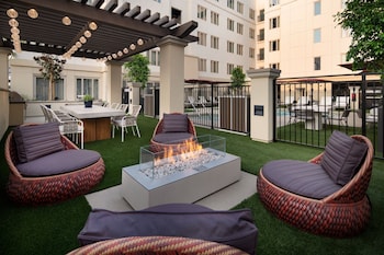 A spacious living area with a staircase, a fireplace, and modern lighting fixtures.