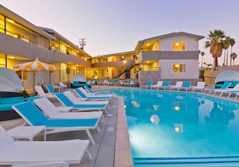 Una piscina al aire libre, camas de piscina gratis, sombrillas