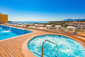 Una piscina al aire libre de temporada, sombrillas, tumbonas