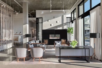 An outdoor seating area with a fire pit, sofas, and wicker chairs.