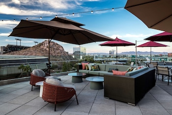 An outdoor bar area with a modern design, featuring a counter with bar stools and a view of the interior.