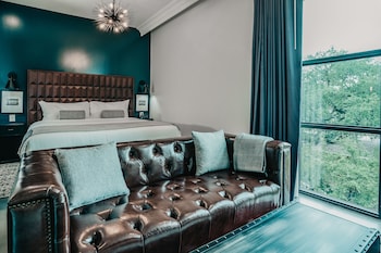 A spacious living room with a checkered floor, a staircase, and a chandelier.
