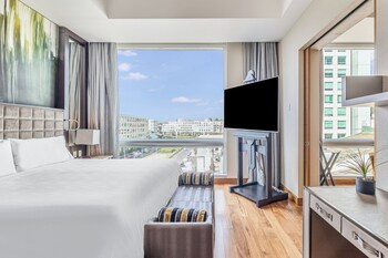 Relax in this stylish living room with a large flat-screen TV, comfortable sofa, and city views.