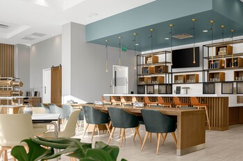 A hotel with a modern exterior, outdoor seating area, and a visible fire feature.