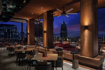 A modern outdoor lounge area with a sofa, chairs, and tables.