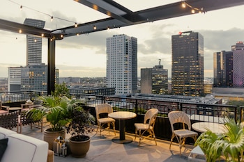 A rooftop pool area with multiple swimming pools and sun loungers.
