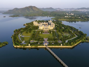 A couple dining at a table with a view of a water body and mountains.