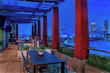 A modern interior with a central dining area, seating arrangements, and a view through large windows.