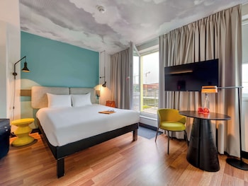 Experience the sleek, modern design of this hotel, featuring large windows and a welcoming entrance.