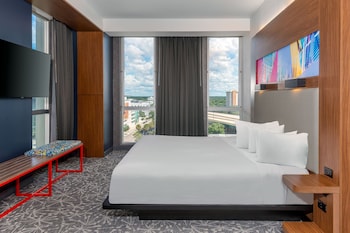 A hotel with a modern facade, multiple floors, and a rooftop pool area.